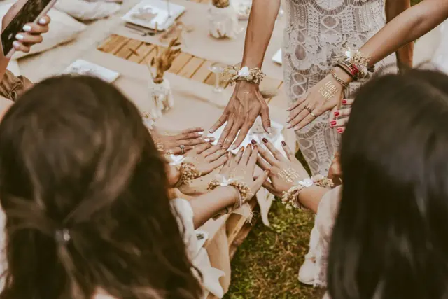 Dłonie ozdobione tatuażami "Team Bride" i bransoletkami z kwiatów. Wspaniałe panieńskie pomysły na celebrację!